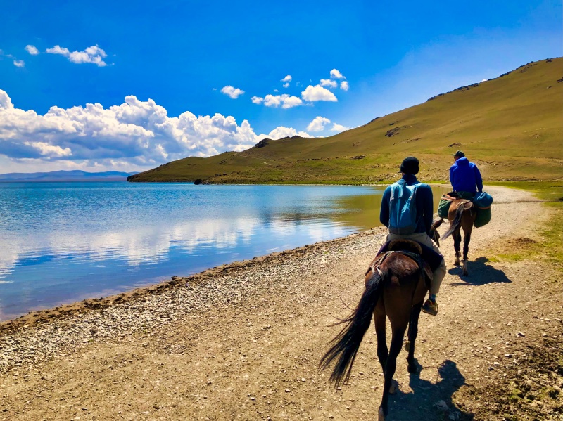 Two people riding a horse - Things to do in Kyrgyzstan