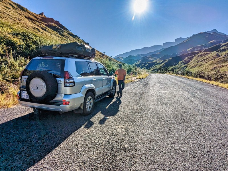 Man standing at the start of the Sani Pass with his car