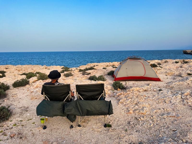 Man watching the ocean while camping in Oman