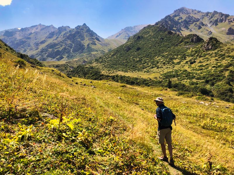 Man hiking through Kyrgyzstan mountains