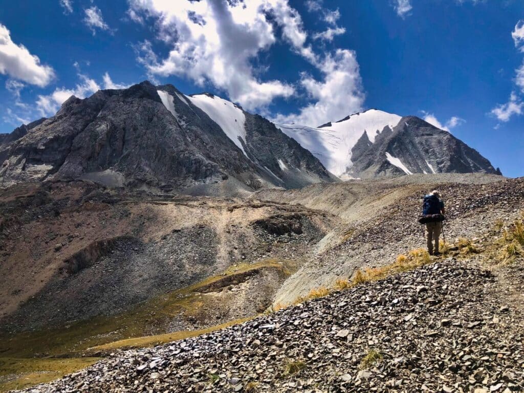 A man in front of a mountain on one of the best Kyrgyzstan hikes
