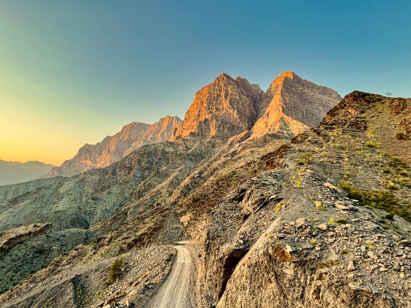 Sharp rocky mountains and a gravel road - common while driving in Oman